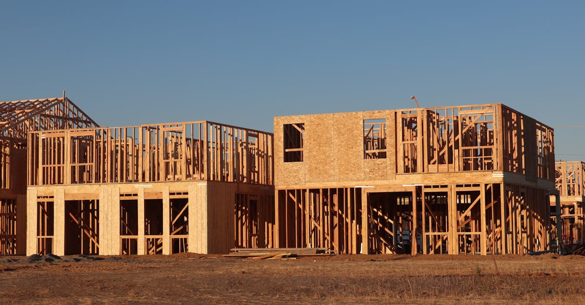 Wooden frames of new homes under construction in Elk Grove, California, during daylight.